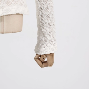 Detailed view of white hollow lace sleeve showing exquisite knit texture and craftsmanship