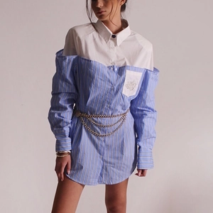 Dettaglio dell'abito a camicia a righe blu con colletto bianco e catena dorata