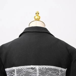 Detail of female black blazer back featuring intricate white floral lace splicing on the hem