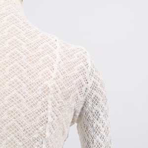 Close-up of intricate white crochet lace texture and refined knit pattern on slim T-shirt