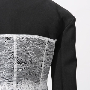 Detail of elegant black blazer featuring intricate white floral lace splicing on the back