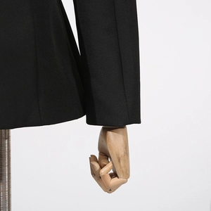Detail shot of black blazer cuffs and hem featuring precise stitching on woven fabric