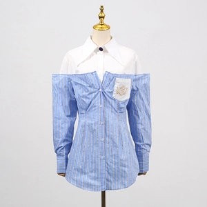 Dettaglio della camicia patchwork a righe blu con tagli sulle spalle e ricamo dorato