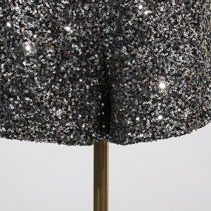 Detailaufnahme des schwarzen Paillettenstoffs mit glänzender Metalltextur und Stickerei