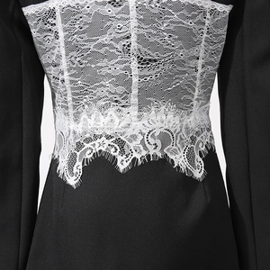 Detailed close-up of intricate white lace splicing on black blazer sleeve and back fabric