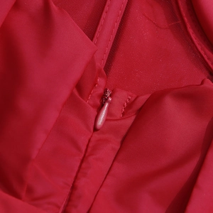 Close-up of high-quality invisible zipper on red satin and mesh ruffle top fabric