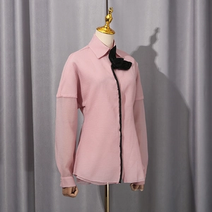 Detail of pink blouse with black bow collar and sheer lantern sleeve patchwork