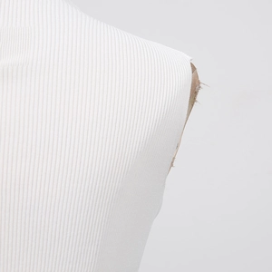 Détail macro de la texture du tissu en maille côtelée blanche et coutures d'épaule soignées