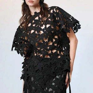Détail du motif floral noir découpé au laser sur un haut de créateur de haute couture