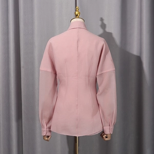 Detail view of pink lantern sleeve blouse showing textured fabric and tailored back seams