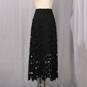 Détail d'une jupe en dentelle noire ajourée avec motifs floraux et ourlet festonné chic