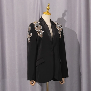 Detailansicht der aufwendigen Gold- und Silber-Strassstickerei auf einem schwarzen Blazer