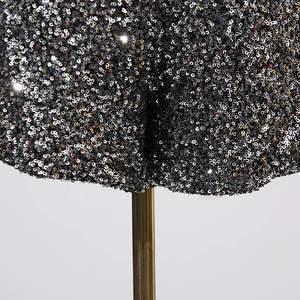 Detailaufnahme funkelnder schwarzer Pailletten auf High-Waist-Shorts mit Metalleffekt
