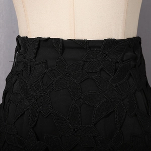 Détail de la taille d'une jupe noire avec dentelle florale 3D et coutures de haute qualité