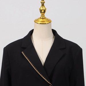 Detailansicht eines schwarzen Blazers mit goldener Lineal-Stickerei am Revers-Kragen