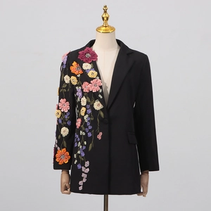 Détail de la broderie florale 3D colorée sur une veste blazer ajustée noire chic
