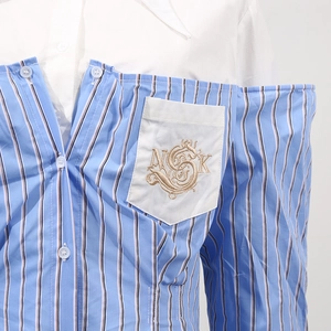 Dettaglio della camicia a righe patchwork con ricamo NCK dorato sulla tasca del petto chic
