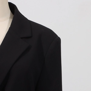 Detailansicht von Revers und Schulterpolster dieses eleganten schwarzen taillierten Blazers