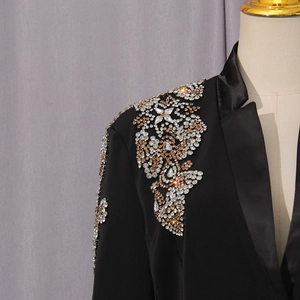 Detail von funkelnden Strasssteinen und Blumenstickerei auf schwarzem Blazer