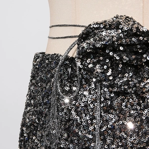 Detailansicht funkelnder schwarzer Pailletten und 3D-Blumenakzent auf High-Waist-Shorts