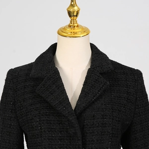 Dettaglio del blazer in tweed nero con filo metallico intrecciato e risvolto classico