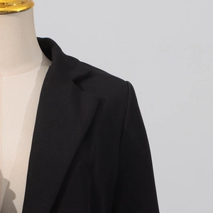 Gros plan détaillé du revers et de l'épaule d'un blazer noir cintré pour femmes