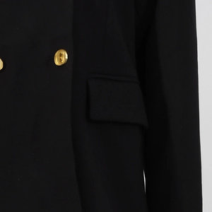 Detail eines schwarzen Blazers mit goldenen Metallknöpfen und einer funktionalen Klappentasche