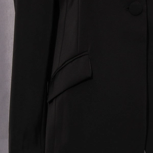 Detail eines schwarzen Blazers mit Pattentasche und passendem stoffbezogenem Knopf