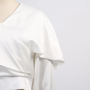 Vue détaillée de la texture en satin blanc et du design élégant des manches à volants