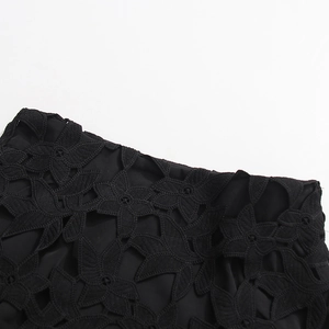 Gros plan sur le tissu en dentelle florale noire avec broderie ajourée et doublure douce