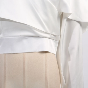 Détail d'un chemisier en satin blanc avec des volants élégants et texture soie de luxe