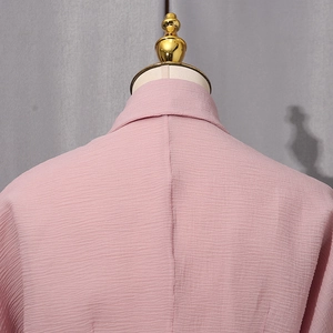 Detail of pink crepe blouse collar and stitching on a professional display mannequin
