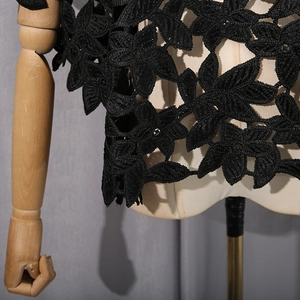 Vue détaillée de la dentelle florale 3D noire sur le haut irrégulier au design creux