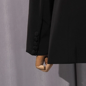 Detail der eleganten schwarzen Blazer-Ärmel mit fünf stoffbezogenen Knöpfen am Ärmelbund