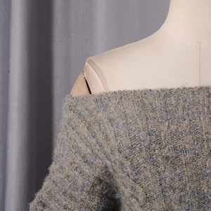 Detail of grey-blue off-shoulder knitted dress showing soft mohair texture and shoulder cutout