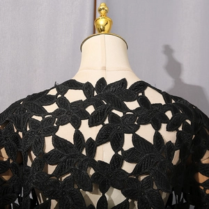 Gros plan sur la broderie en dentelle noire lourde avec motifs floraux ajourés sur haut