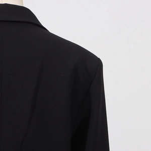 Detailaufnahme der Schulter eines schwarzen Blazers mit feiner Textur und hochwertiger Naht