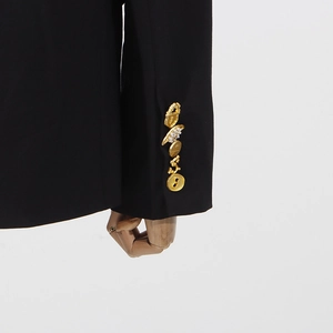 Nahaufnahme eines schwarzen Blazer-Ärmels mit fünf exklusiven goldenen Zierknöpfen