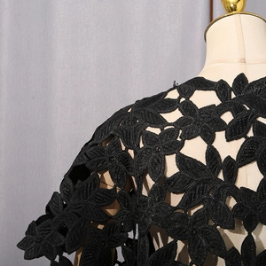 Détail de dentelle crochetée noire à motif floral sur haut à manches courtes