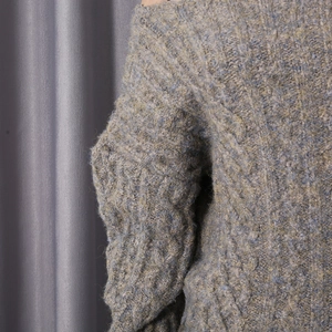 Close-up of chunky cable knit texture in blue and yellow blend with off-shoulder detail