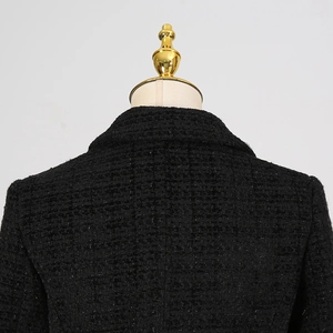 Dettaglio ravvicinato della trama in tweed nero su colletto e spalla del blazer
