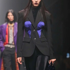 Detail of a chic black blazer featuring a purple corset-style bodice and pocket flaps