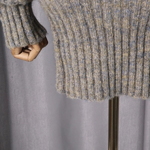 Detailed macro of the mixed-color knit texture and ribbed hem on the dress