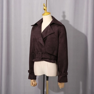 Détail d'une veste courte en daim marron foncé avec un grand revers et une ceinture