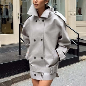 Détail du manteau croisé en cuir gris clair avec grands revers et ceinture assortie