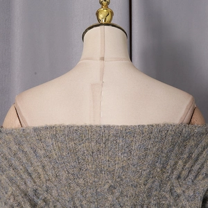 Close-up of grey knit dress fabric showing multi-color textured yarn and off-shoulder detail