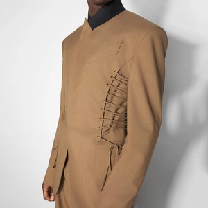 Detail of metal eyelets and side lace-up design on brown designer blazer jacket