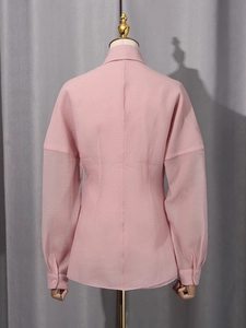 Pink lantern sleeve shirt featuring textured fabric and elastic waist design on the back