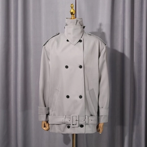 Détails d'une veste trench gris clair avec épaulettes et boutons à double boutonnage