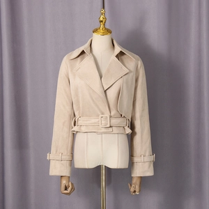 Détail du revers large et de la texture du tissu sur une veste courte beige pour femme